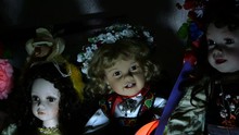 Several Dolls On A Shelf Of An Old House In Dramatic Lighting, Looking Mysterious And Otherworldly Inspire Fear. Close-up.