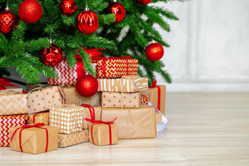 stack of wrapped presents under christmas tree