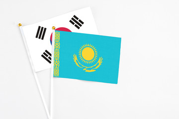 Wall Mural - Kazakhstan and South Korea stick flags on white background. High quality fabric, miniature national flag. Peaceful global concept.White floor for copy space.
