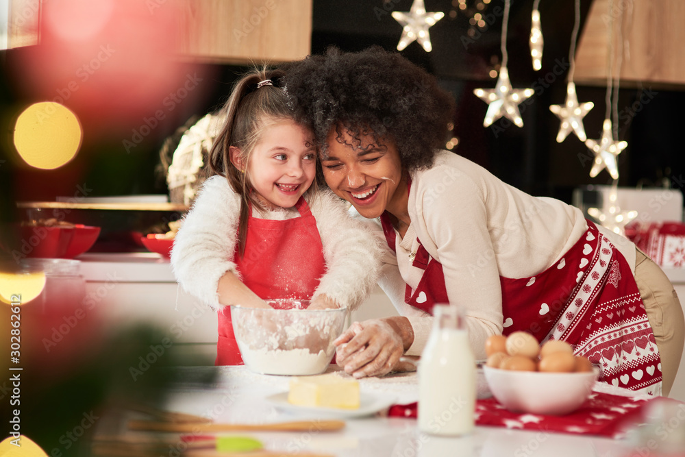 Girl and her mum baking cookies for Christmas - obrazy, fototapety, plakaty 