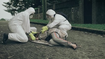 Sticker - Man and woman in bacteriological protective suits running to help a woman passed out on the floor