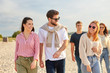 © Syda Productions - friendship, leisure and people concept - group of happy friends walking along beach in summer