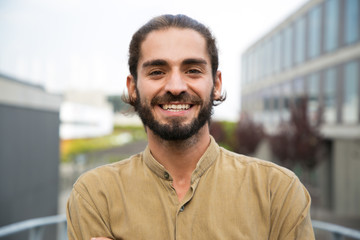 handsome happy bearded man. portrait of cheerful young man standing outdoors and smiling at camera. 