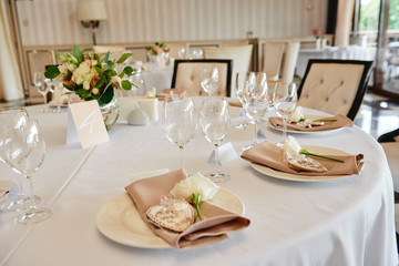 Table setting with sparkling wineglasses and cutlery on table, copy space. Menu mockup, place setting at wedding reception. Table served for wedding banquet in restaurant