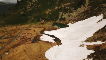 Wall Mural - Aerial tracking shot of wild mountain landscape with little lake