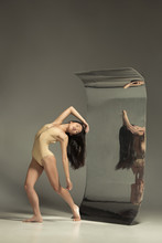 Young And Stylish Modern Ballet Dancer On Brown Background With Mirror. Illusion Reflections On Surface. Magic Of Flexibility, Motion. Parallel Dreamworld. Concept Of Creative Art, Action, Inspiring.