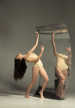 Young And Stylish Modern Ballet Dancer On Brown Background With Mirror. Illusion Reflections On Surface. Magic Of Flexibility, Motion. Parallel Dreamworld. Concept Of Creative Art, Action, Inspiring.