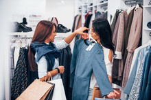 Looking For A Warm Clothes. Two Young Women Have A Shopping Day Together In The Supermarket