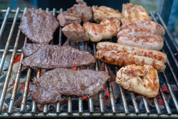 close-up Assorted delicious grilled meat and bratwurst  over the coals on a barbecue