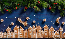 Christmas Background, Image Created From Gingerbread Houses, Fresh Yew Branches And Gingerbread Stars  On A Dark Blue  Background. Christmas Gingerbread Cookies Town