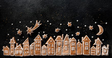 Christmas Background, Gingerbread  Cookies Houses And Gingerbread Stars  On A Black  Background. Christmas Gingerbread Town