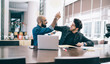 © BullRun - Smiling men giving high five working in team