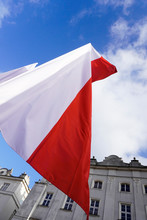 Polish Red And White Flags In The Old Town In Front Of The Building On A Sunny Day.May 1, November 11, Flag, Independence Or Labor Day. Public Holiday In Poland. Decoration Of The City With Flags.