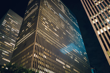 Skyscraper rising in business district of megalopolis with real estate for corporate rent inside,evening view of tall modern constructed building shining with light from windows of headquarters