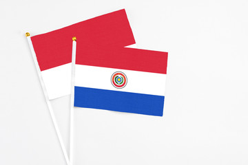 Paraguay and Monaco stick flags on white background. High quality fabric, miniature national flag. Peaceful global concept.White floor for copy space.