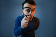 © 1STunningART - Curious young man with magnifying glass Isolated on grey background.