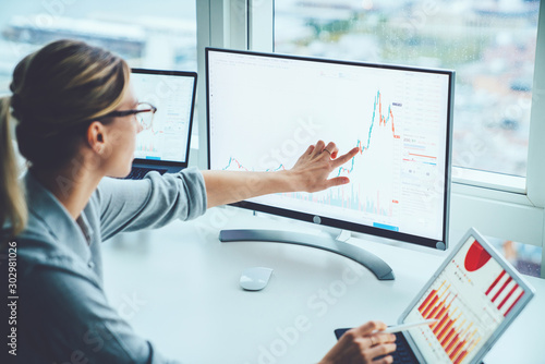 Fotomural Business woman study financial market to calculate possible risks and profits