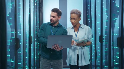 Wall Mural - professional diverse team of data center specialists coworking in server room. female and male engin