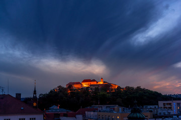 Wall Mural - Castle Spilberk Brno city slow moving clouds captured just from castle turn public light on going from blue hour to night time with colored sky and clouds.