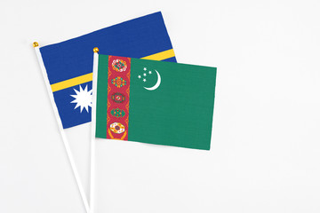 Turkmenistan and Nauru stick flags on white background. High quality fabric, miniature national flag. Peaceful global concept.White floor for copy space.