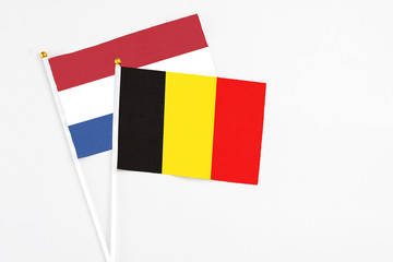 Wall Mural - Belgium and Netherlands stick flags on white background. High quality fabric, miniature national flag. Peaceful global concept.White floor for copy space.