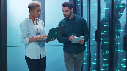 Wall Mural - multi-ethnic team of database specialists inspecting operative rack servers supercomputer coworking 