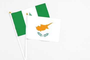 Cyprus and Norfolk Island stick flags on white background. High quality fabric, miniature national flag. Peaceful global concept.White floor for copy space.