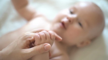 baby holds mother's hand, slow motion