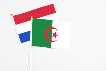 Algeria and Paraguay stick flags on white background. High quality fabric, miniature national flag. Peaceful global concept.White floor for copy space.