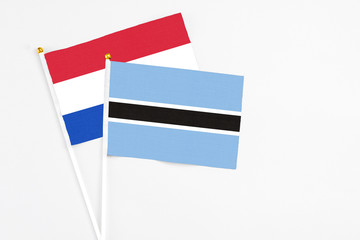 Botswana and Paraguay stick flags on white background. High quality fabric, miniature national flag. Peaceful global concept.White floor for copy space.