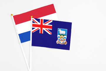 Falkland Islands and Paraguay stick flags on white background. High quality fabric, miniature national flag. Peaceful global concept.White floor for copy space.