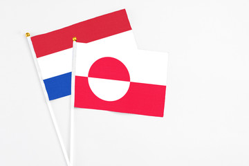 Greenland and Paraguay stick flags on white background. High quality fabric, miniature national flag. Peaceful global concept.White floor for copy space.
