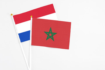 Morocco and Paraguay stick flags on white background. High quality fabric, miniature national flag. Peaceful global concept.White floor for copy space.