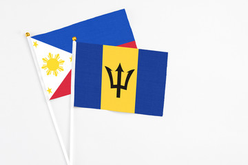 Barbados and Philippines stick flags on white background. High quality fabric, miniature national flag. Peaceful global concept.White floor for copy space.
