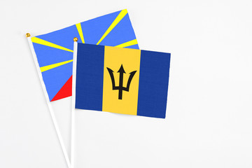 Barbados and Reunion stick flags on white background. High quality fabric, miniature national flag. Peaceful global concept.White floor for copy space.