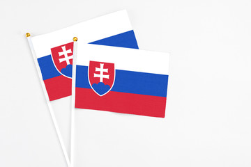 Slovakia and Slovakia stick flags on white background. High quality fabric, miniature national flag. Peaceful global concept.White floor for copy space.