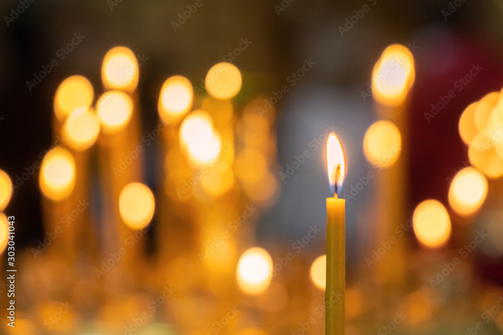 Candle light in christian church warm tone with dark black background - obrazy, fototapety, plakaty 