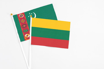 Lithuania and Turkmenistan stick flags on white background. High quality fabric, miniature national flag. Peaceful global concept.White floor for copy space.