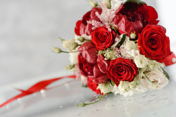 wedding bouquet of red and white flowers on a glass table