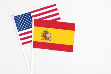Wall Mural - Spain and United States stick flags on white background. High quality fabric, miniature national flag. Peaceful global concept.White floor for copy space.
