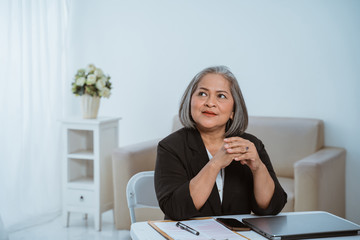 Wall Mural - Confident senior business woman when sitting and thinking business strategy