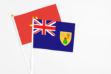 Turks And Caicos Islands and Vietnam stick flags on white background. High quality fabric, miniature national flag. Peaceful global concept.White floor for copy space.