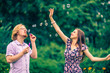 © Voyagerix - Couple blowing bubbles outdoor