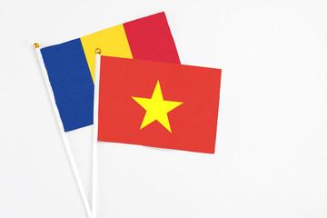 Wall Mural - Vietnam and Romania stick flags on white background. High quality fabric, miniature national flag. Peaceful global concept.White floor for copy space.