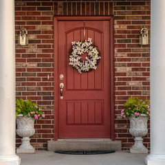 Square Front door to a house flanked by two pillars