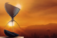 Falling Sand In A Hourglass With Twilight Sky Background