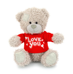 Wall Mural - Cute bear doll with red LOVE YOU shirt isolated on white background with shadow reflection. Playful bright brown bear sitting on white underlay. Teddy bear plush stuffed puppet toy.