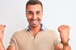 © Krakenimages.com - Young handsome man wearing elegant t-shirt over isolated background screaming proud and celebrating victory and success very excited, cheering emotion