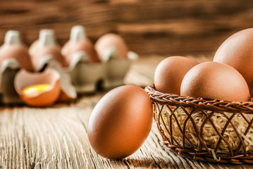 Wall Mural - Eggs in basket. Brown chicken egges on wooden vintage table. Fresh egg on morning breakfast.