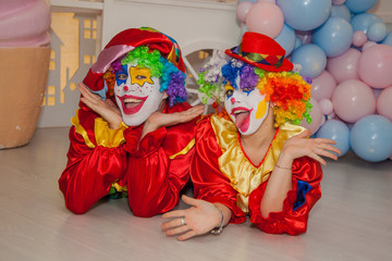 Wall Mural - Funny clowns from the circus. Clown boy and clown girl show emotions